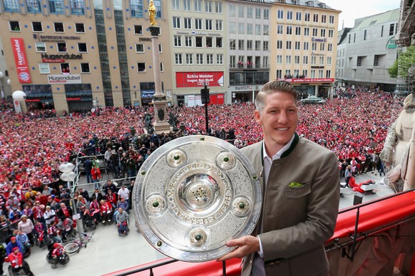 Bastian Schweinsteiger of Bayern Munich holds the German Championship winners trophy as the team celebrate winning the German Championship title on the town hall balcony at Marienplatz in Munich, Germ ...