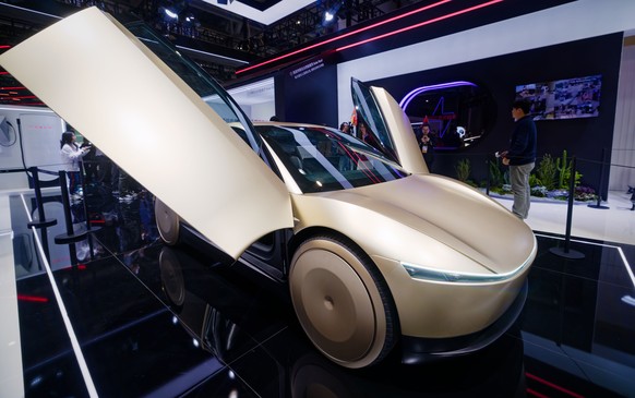 epa12504352 People look at a Cybercab vehicle on display at the Tesla booth during the 7th China International Import Expo (CIIE) in Shanghai, China, 05 November 2025. The 7th China International Impo ...