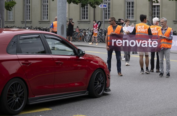 Environmental activists of Renovate Switzerland protest during a slow protest march on a road in Bern, Switzerland, on Saturday, July 1, 2023. (KEYSTONE/Anthony Anex)