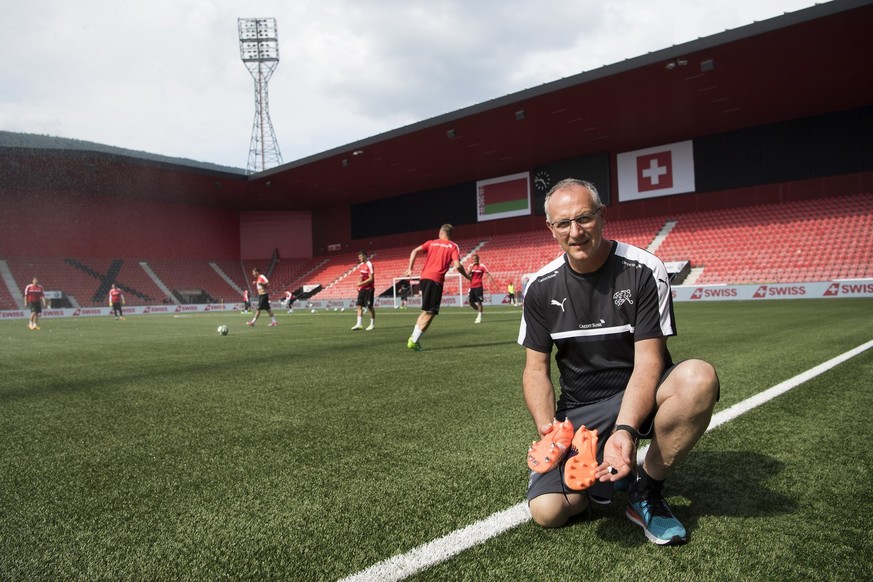 Jean-Benoit Schuepbach, chief of material, poses with football shoes next to the synthetic pitch during a training session of the Swiss soccer national team, at the Stadium Maladiere, in Neuchatel, Sw ...