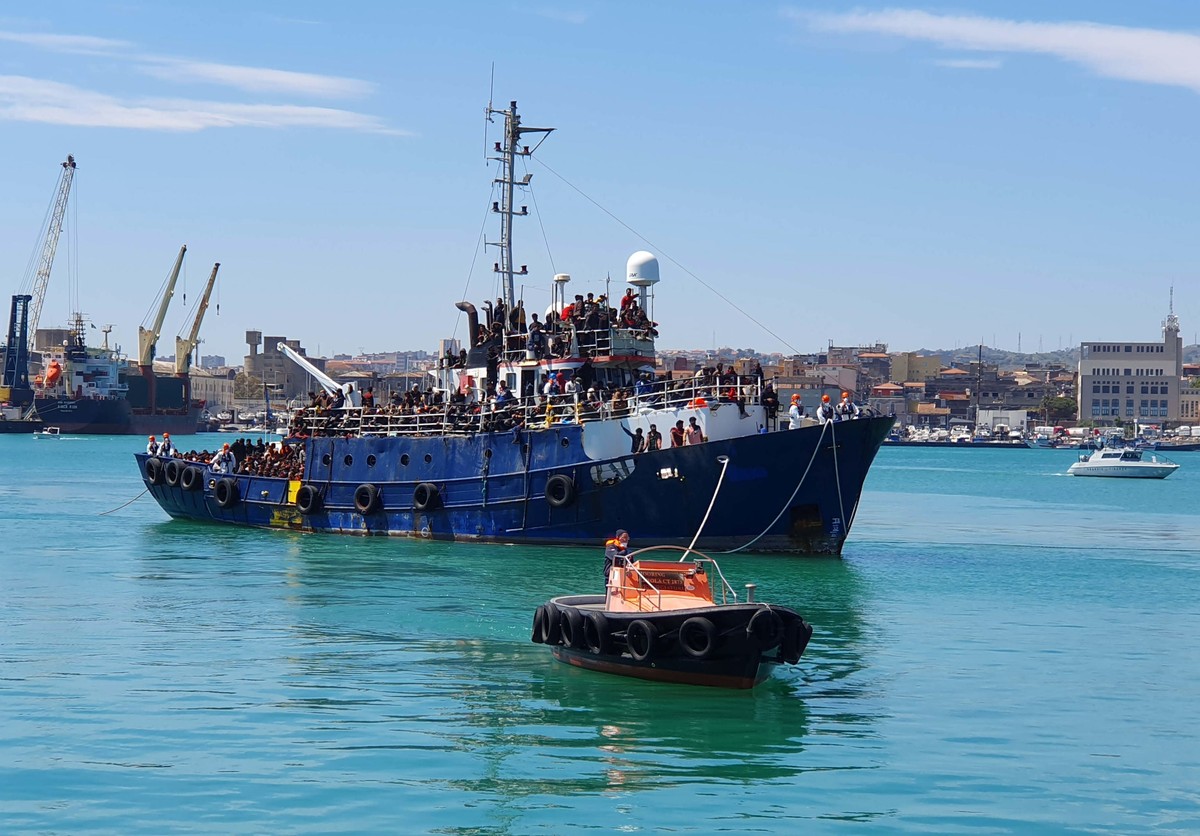 epa10569478 A trawler carrying about 600 migrants rescued some 100 miles of the coast of Sicily is towed by a tugboat in the port of Catania, Italy, 12 April 2023. The vessel was escorted by the ' ...