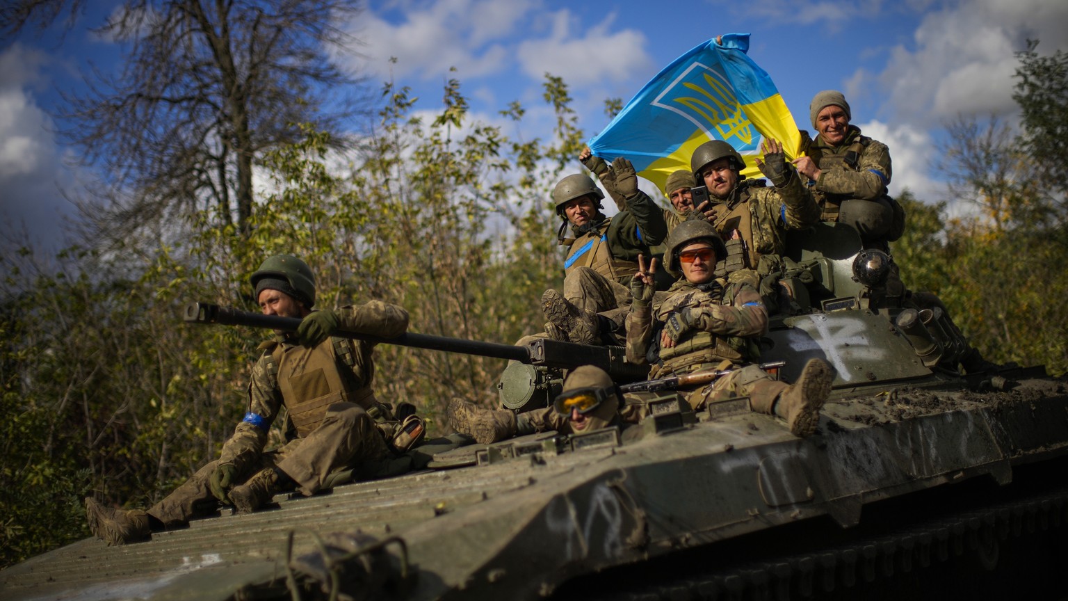 FILE - Ukrainian soldiers sit on an armoured vehicle as they drive on a road between Izium and Lyman, recently retaken areas in Ukraine, on Oct. 4, 2022. Ukraine has successfully pressed its counterof ...