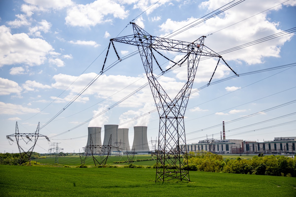 epa12094111 Pylons carry high voltage electricity cables across a field past cooling towers operating at the Dukovany nuclear power plant operated by CEZ AS, near the village of Dukovany, Czech Republ ...
