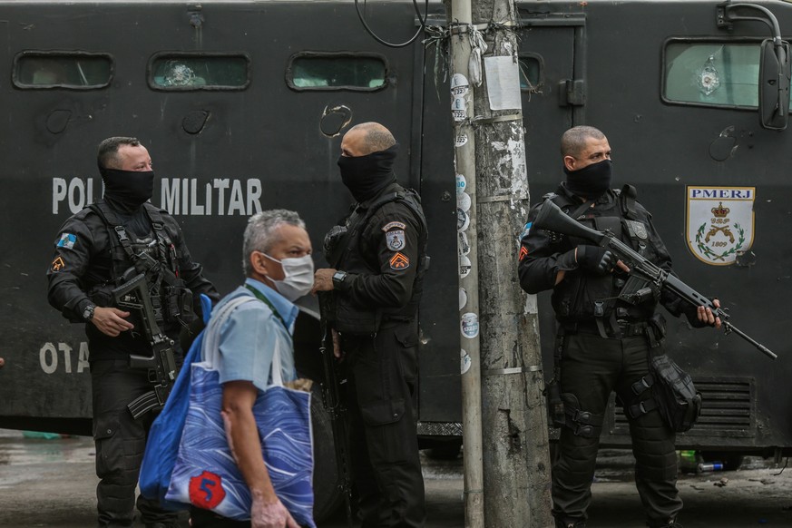 epa09183300 Military policemen stand on guard in Jacarezinho favela in Rio de Janeiro, Brazil, 07 May 2021, a day after 25 people died, including a police officer five more people were injured during  ...