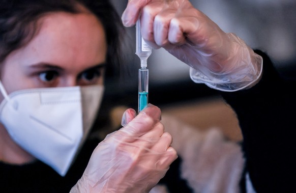 epa09666170 A medical worker fills syringes with Moderna and Biontech vaccines against Covid-19 inside the Sage Beach Bar and Restaurant l in Berlin, Germany, 04 January 2021. In a measure to reach mo ...