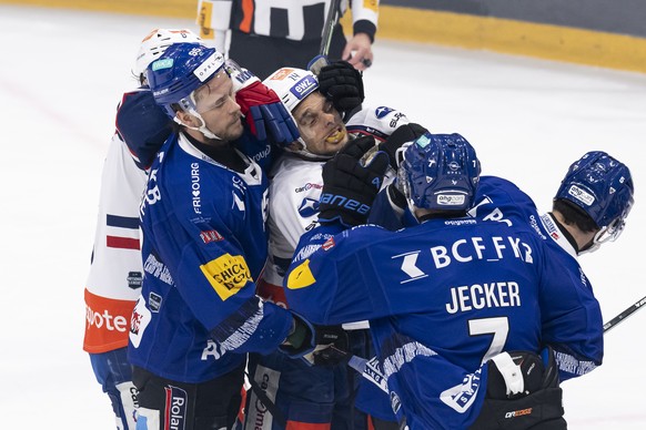 Jacob De la Rose (HCFG), Chris Baltisberger (ZSC), Benoit Jecker (HCFG) und Simon Seiler (HCFG) kaempfen sich, bei dem Spiel der Eishockey National League zwischen dem HC Fribourg Gotteron und den ZSC ...