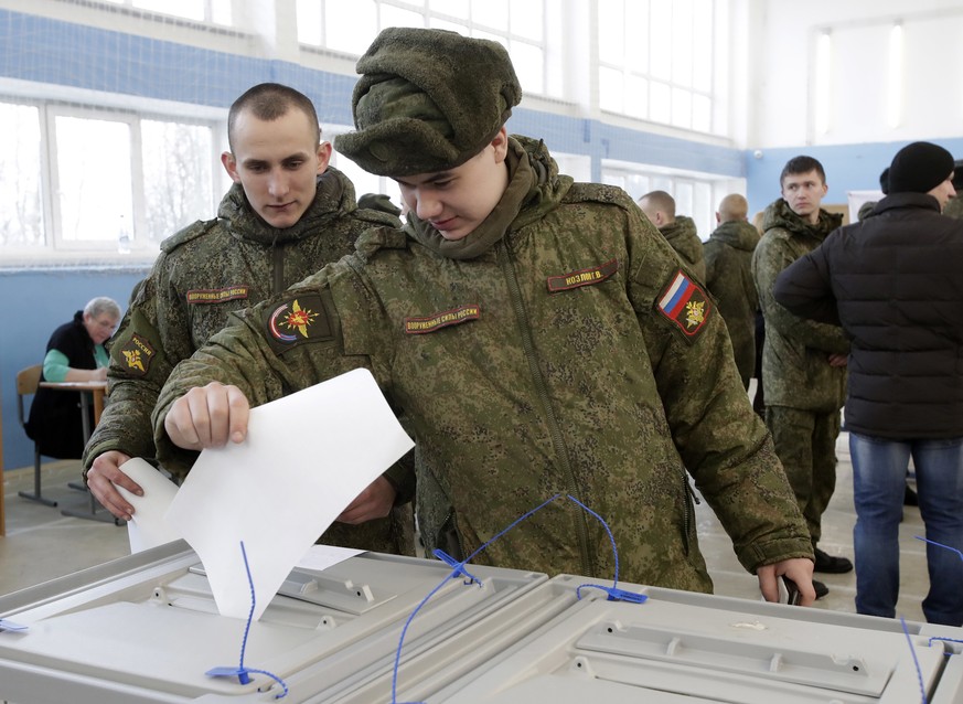 Russian servicemen vote in the Russian presidential election in St. Petersburg, Russia, Sunday, March 18, 2018. Russians are voting in a presidential election in which Vladimir Putin is seeking a four ...