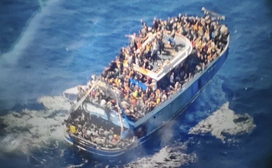 This undated image from the Greek Coast Guard on Wednesday, June 14, 2023, shows dozens of people practically covering every free area of ​​deck on a battered fishing boat that leaves…