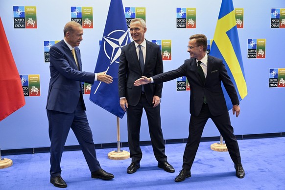 epa10738049 Turkish President Recep Tayyip Erdogan (L) shakes hands with Swedish Prime Minister Ulf Kristersson (R) as the Secretary General of NATO Jens Stoltenberg (C) looks on during their meeting  ...