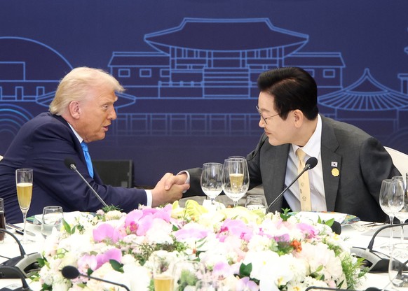 epa12490236 South Korean President Lee Jae Myung (R) and US President Donald Trump (L) attend a special dinner held for state leaders at the Hilton Hotel in the southeastern city of Gyeongju, South Ko ...