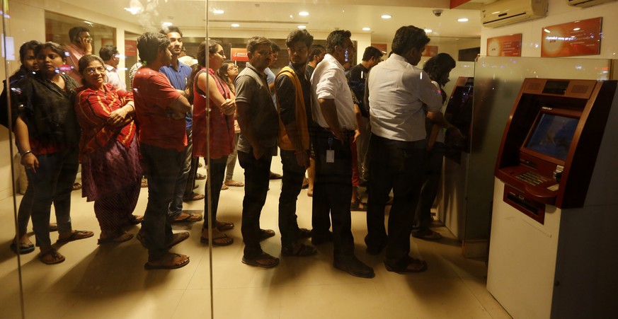 Indians stand in queues in front of ATM machines in Ahmadabad, India, Tuesday, Nov. 8, 2016. India&#039;s highest-denomination currency notes are being withdrawn immediately from circulation, the coun ...