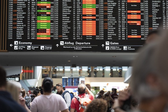 Passengers look at screens informing them of the flight situation, on Friday, 19 July 2024, at the airport Zurich in Kloten, Switzerland. Due to a worldwide IT breakdown, check-in for air travellers a ...