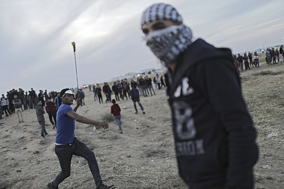 epa06642557 A Palestinian protester throws stones during clashes with Israeli troops along the border between Israel and Gaza Strip, in the eastern Gaza Strip, 02 April 2018 (issued 03 April 2018). Tw ...