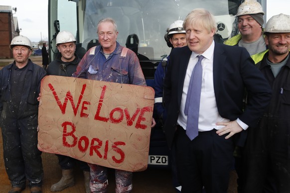 Britain&#039;s Prime Minister Boris Johnson poses with workers during a visit to Wilton Engineering Services, part of a General Election campaign trail stop in Middlesbrough, England, Wednesday, Nov.  ...