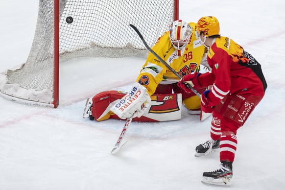Le gardien biennois Joren Van Pottelberghe, gauche, a la lutte pour le puck avec le top scorer PostFinance lausannois Denis Malgin, droite, lors du match du championnat suisse de hockey sur glace de N ...