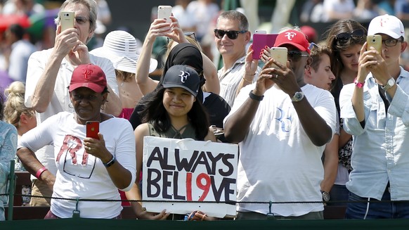 Fans of Roger Federer watch him play during a warm up training session prior to his second round match against Dusan Lajovic of Serbia, at the Wimbledon Championships at the All England Lawn Tennis Cl ...