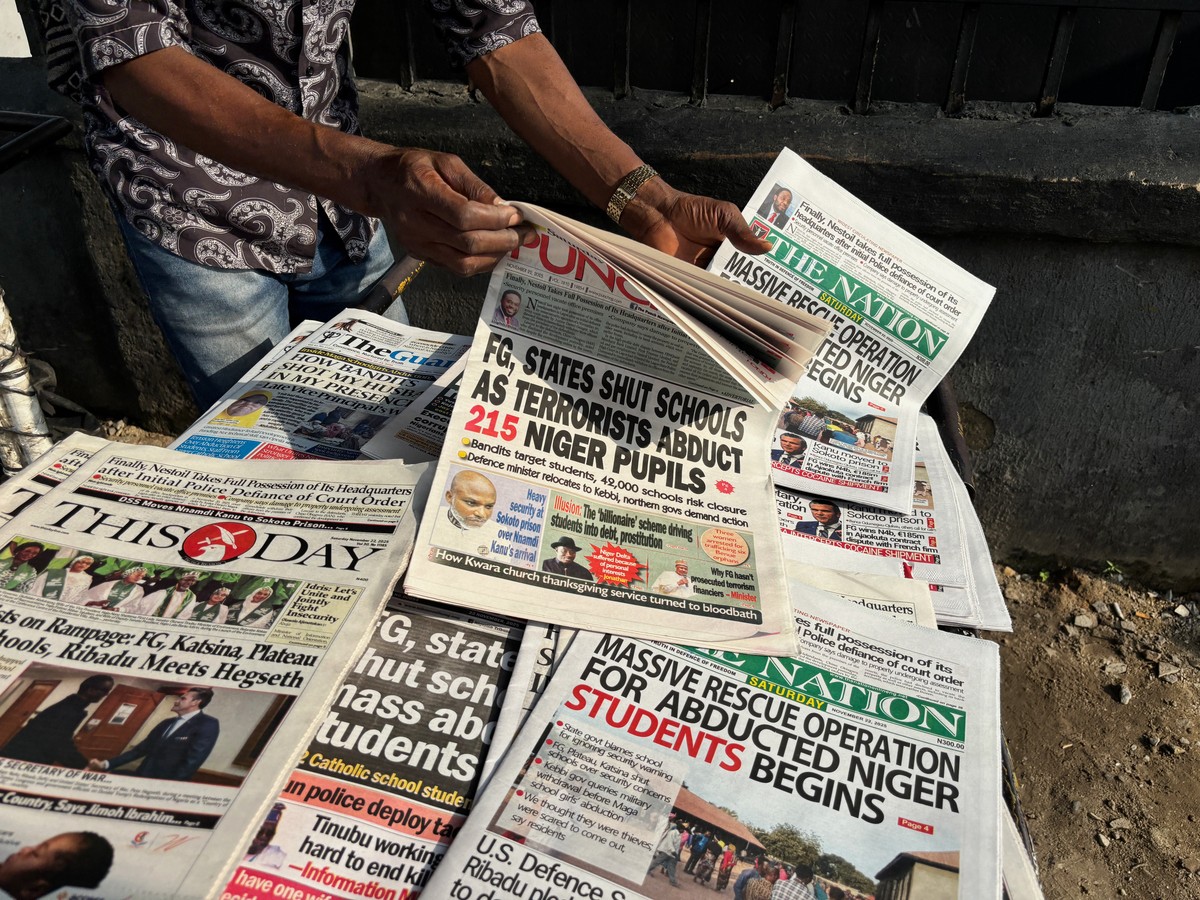 A street vendor in Lagos displays local newspapers with headlines on gunmen abducting schoolchildren and staff of the St. Mary's Catholic Primary and Secondary School in Papiri community in Niger ...