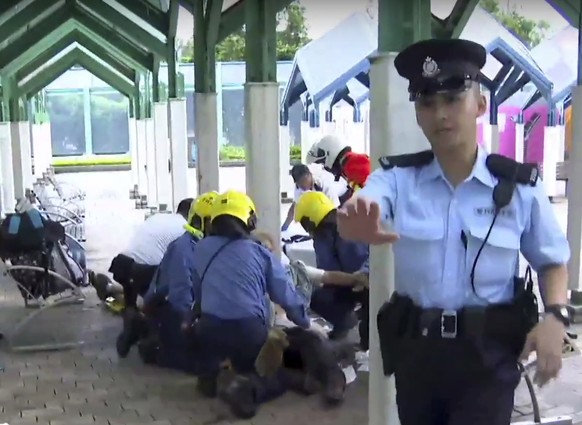 This frame grab from video provided by iCable TV, shows a victim receiving medical treatment at the Quarry Bay Park in Hong Kong, Tuesday, June 26, 2018. Hong Kong media say four people have been inju ...