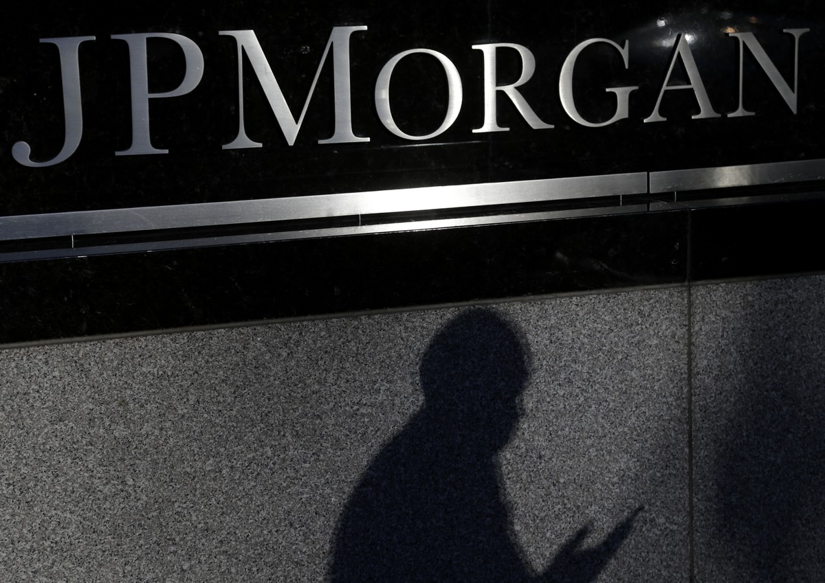 FILE - In this Nov. 19, 2013, file photo, the shadows of a pedestrian is cast under a sign in front of JPMorgan Chase &amp; Co. headquarters in New York. JPMorgan Chase on Monday, Nov. 3, 2014 said th ...