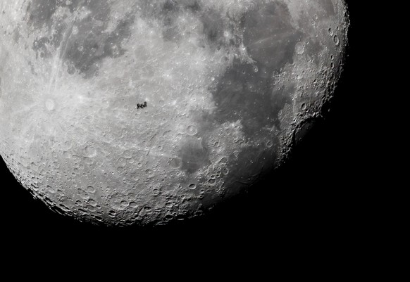 The International Space Station (ISS) orbiting the Earth is captured in the foreground of the Moon from Filakovo, southern Slovakia, early Wednesday, Nov. 1, 2023. (Peter Komka/MTI via AP)