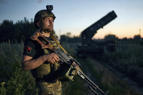 A Ukrainian soldier looks on next to a Russian TOS-1A Solntsepyok heavy flamethrower rocket launcher, captured by the Ukrainian army battalion &quot;Da Vinci&quot;, on the frontline near Kreminna, Luh ...