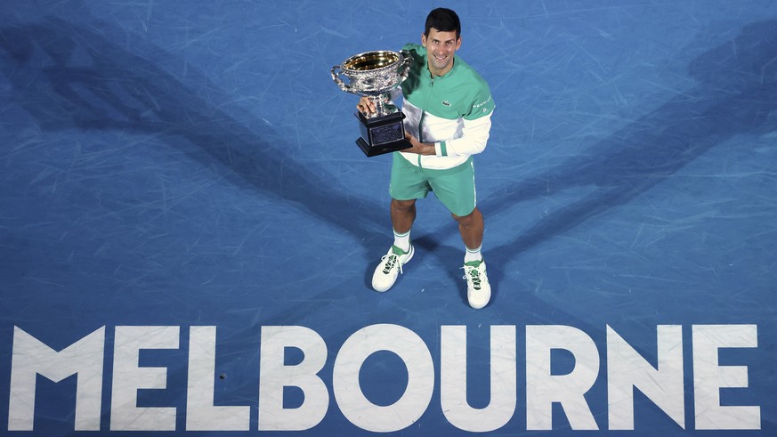 FILE - Feb. 21, 2021, file photo Serbia&#039;s Novak Djokovic holds the Norman Brookes Challenge Cup after defeating Russia&#039;s Daniil Medvedev in the men&#039;s singles final at the Australian Ope ...