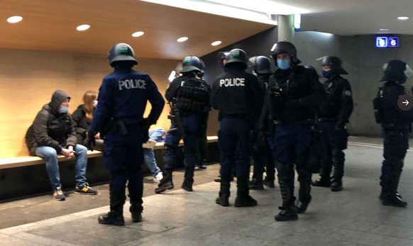 Berner Polizisten kontrollieren Leute im Bahnhof.