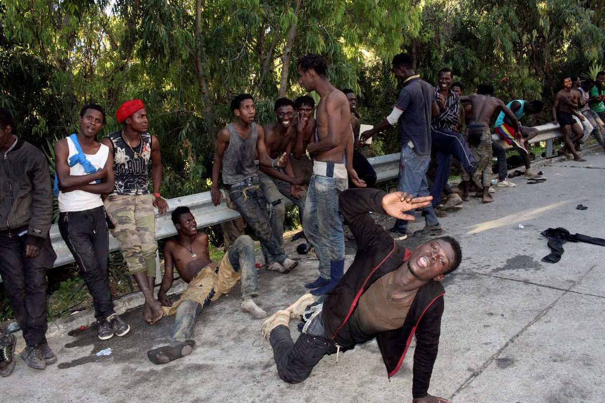 epa06911256 Several migrants celebrate after they managed to jump the border fence between Spain and Morocco, in Ceuta, a Spanish enclave in northern Africa, 26 July 2018. Some 400 migrants reached Sp ...