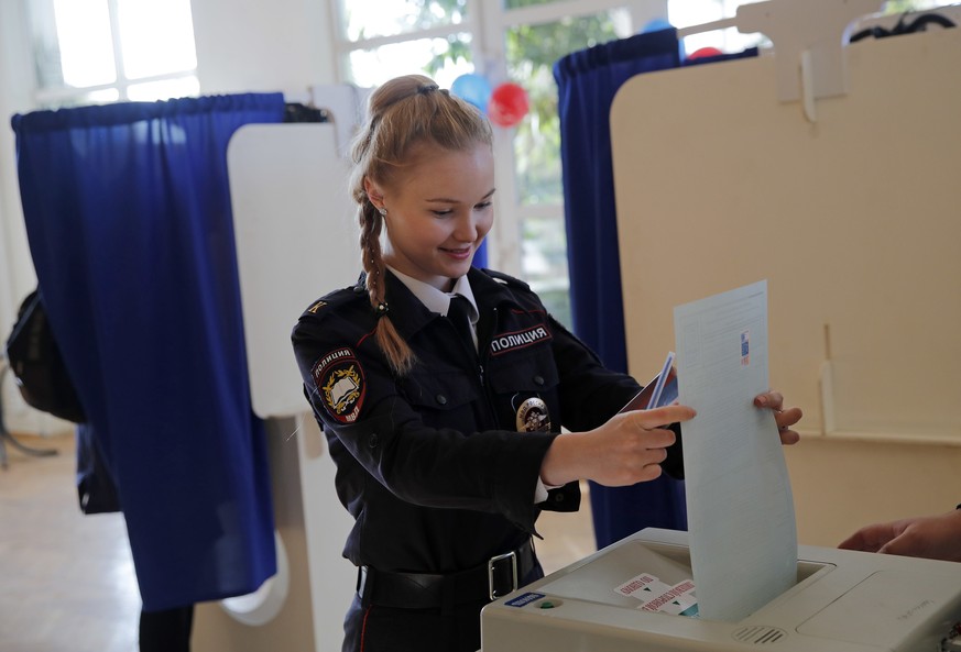 A police cadet casts her vote in the presidential election in Moscow, Russia, Sunday, March 18, 2018. Russians are voting in a presidential election in which Vladimir Putin is seeking a fourth term in ...