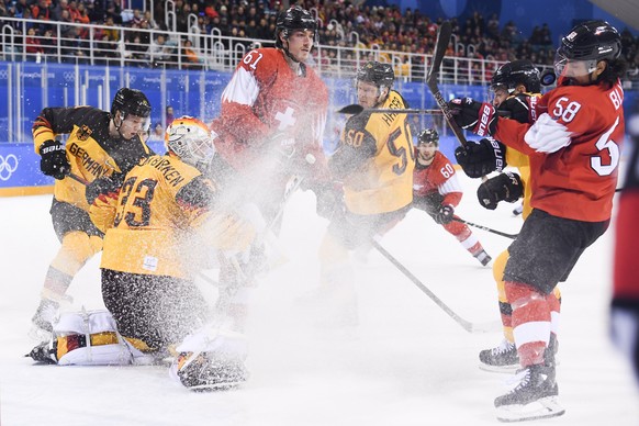 epa06546384 (L-R) Danny aus den Birken, goalkeeper of Germany, Fabrice Herzog of Switzerland, Patrick Hager of Germany, and Eric Blum of Switzerland fight for the puck during the Men&#039;s Ice Hockey ...