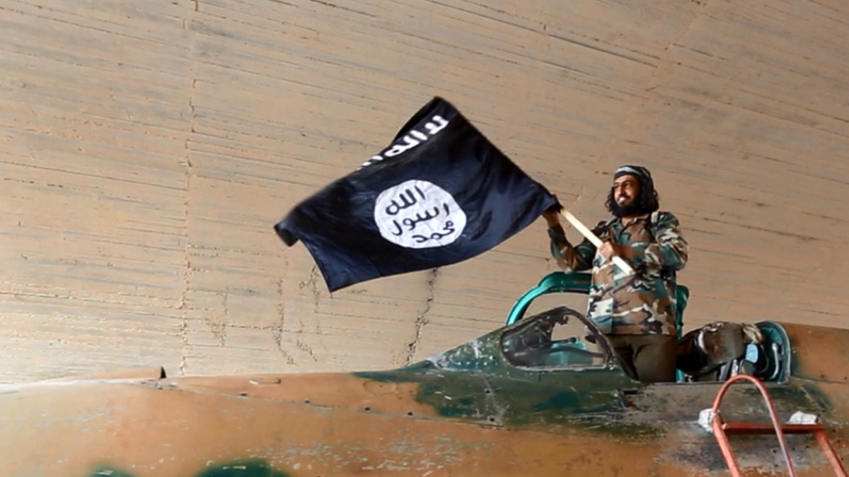 Ein Kämpfer der Terrormiliz Islamischer Staat (IS) mit einer Flagge. (Symbolbild)