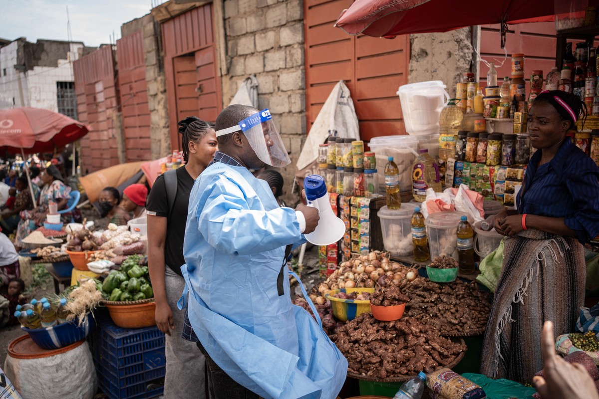 epa13002646 A coordinator with U-Reporters, an UNICEF program to engage and inform local communities, wears a protective gown as he takes part in a campaign to raise awareness against Ebola in Goma, N ...
