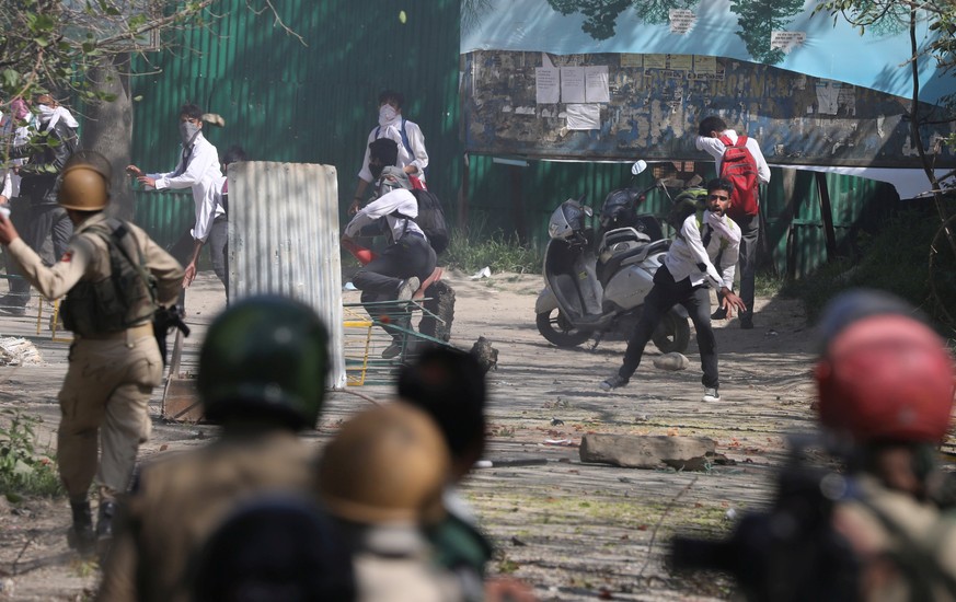 epa05912044 Kashmiri students and Indian police throw stones at each other during clashes at a school in Srinagar, the summer capital of Indian Kashmir, 17 April 2017. Over 50 Kashmiri students were i ...