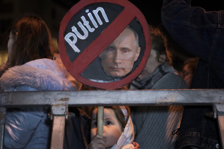 A young girl holds a placard depicting Russian President Vladimir Putin during a protest against the Russian invasion of Ukraine, outside the Russian Embassy in Tel Aviv, Israel, Saturday, March 5, 20 ...