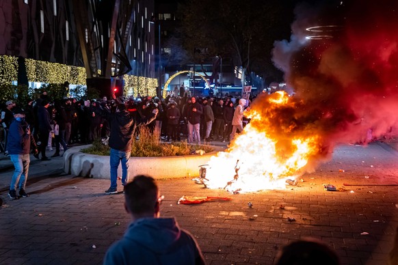 epa09592757 A scooter set on fire during a protest against the 2G policy in Coolsingel, Rotterdam, Netherlands, 19 November 2021. Hundreds of demonstrators have gathered to protest against the tighten ...