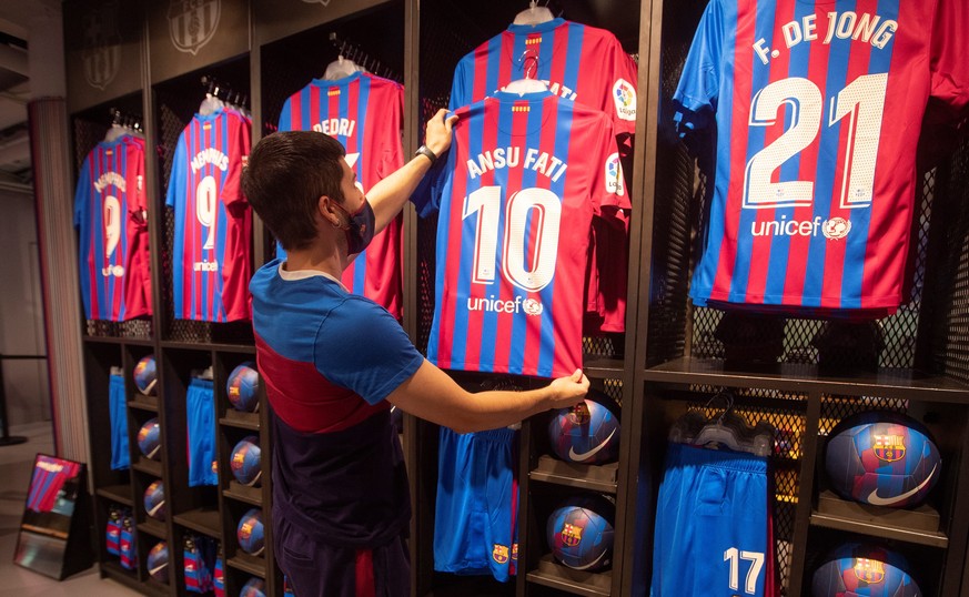 epa09441010 A salesman hangs the new FC Barcelona&#039;s jersey for Ansu Fati, who will be wearing number 10 replacing Argentinian legend Lionel Messi, at Bar?