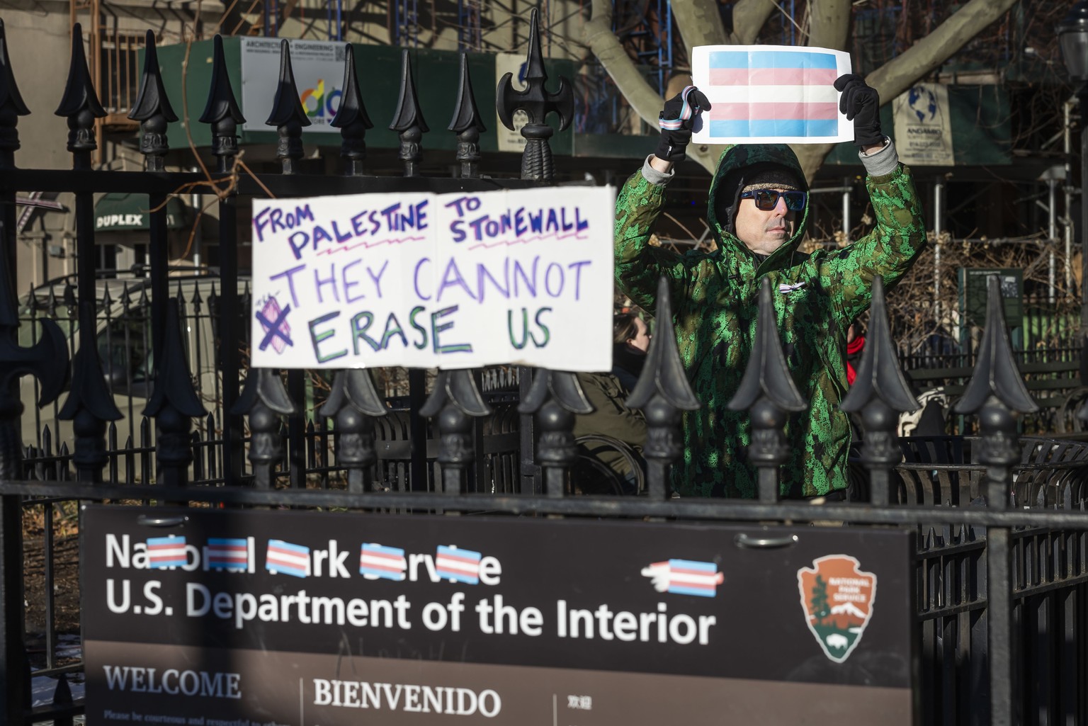 epa11896944 A person holds up a transgender flag at the Stonewall National Monument, an officially designated United States National Park, in New York, New York, USA, 14 February 2025. The US National ...