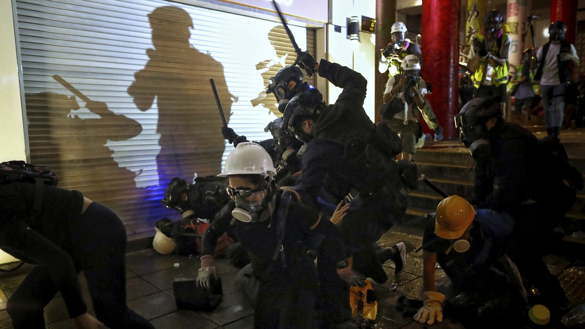 Policemen charge towards protesters during the anti-extradition bill protest at Tsim Sha Tsui in Hong Kong, Sunday, Aug. 11, 2019. Police fired tear gas late Sunday afternoon to try to disperse a demo ...