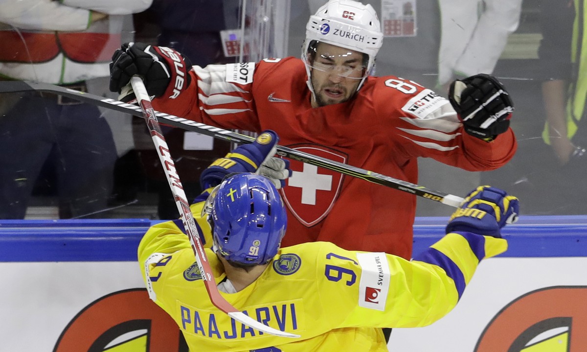 Switzerland's Simon Moser, above, challenges for the puck with Sweden's Magnus Paajarvi during the Ice Hockey World Championships final match between Sweden and Switzerland at the Royal aren ...
