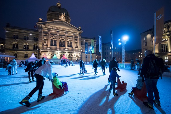 People enjoy ice skating on a temporary ice track in front of the federal parliament buidling in Bern, Switzerland, on Friday, December 23, 2016. (KEYSTONE/Anthony Anex)

Die Menschen geniessen eine ...