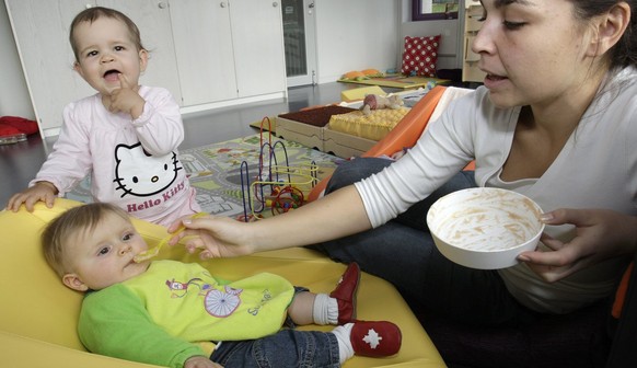 Une employee nourit un bebe dans la creche garderie Crechendo le jour de son inauguration au siege de La Mobiliere Vie ce lundi 22 octobre 2007 a Nyon. La Mobiliere Vie a transforme une partie de son  ...