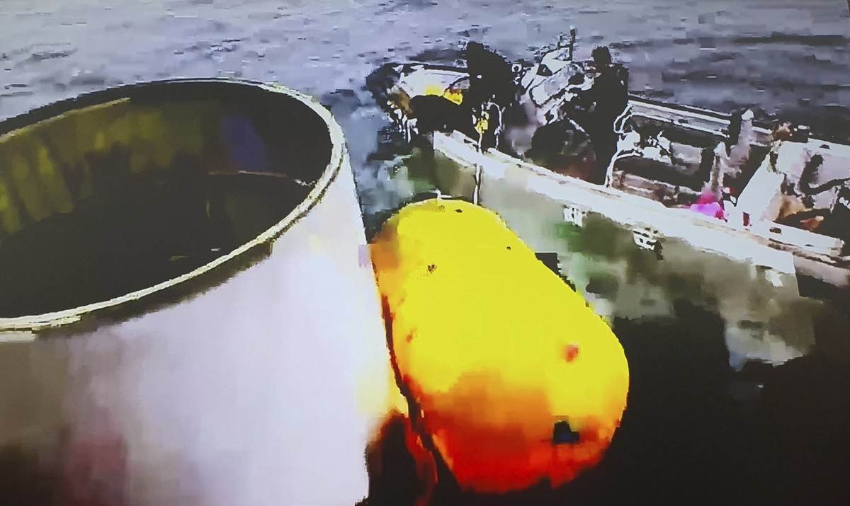 This photo provided by South Korea's Defense Ministry, shows an object, left, salvaged by South Korea's military that is presumed to be part of the North Korean space-launch vehicle that cra ...