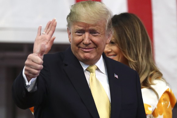 epa07606901 US President Donald J. Trump (L) and First Lady Melania Trump (R) react during a visit to Japanese and US troops aboard Japan Maritime Self-Defense Force's (JMSDF) helicopter carrier ...