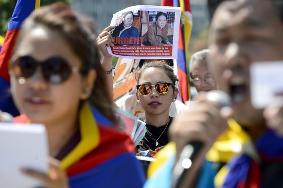 Tibetans living in Switzerland hold placards and Tibetan flags, during a rally on the &quot;Place des Nations&quot; in front of the European headquarters of the United Nations, in Geneva, Switzerland, ...