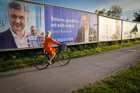 A cyclist rides past election posters in Zagreb, Croatia, Sunday, April 14, 2024. Croatia this week holds a parliamentary election following a campaign that was marked by heated exchanges between the  ...