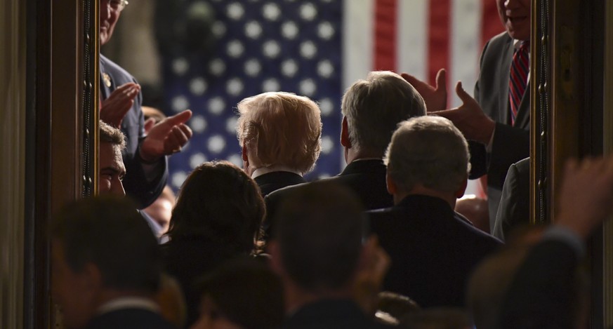 FILE- In this Jan. 30, 2018, file photo President Donald Trump walks into the House Chamber as he arrives for his State of the Union address to a joint session of Congress on Capitol Hill in Washingto ...