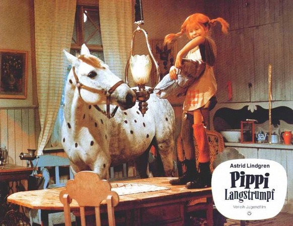Pippi in ihrer kunterbunten Villa, ihr Pferd Kleiner Onkel – wie es sich gehört – im Wohnzimmer.