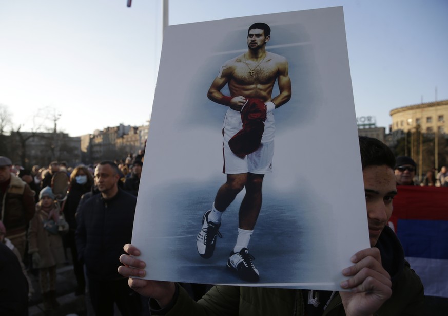epa09672117 A supporter of Serbian tennis player Novak Djokovic holds a banner during a rally in support of Djokovic, in Belgrade, Serbia, 07 January 2022. Tennis world number one Novak Djokovic, curr ...