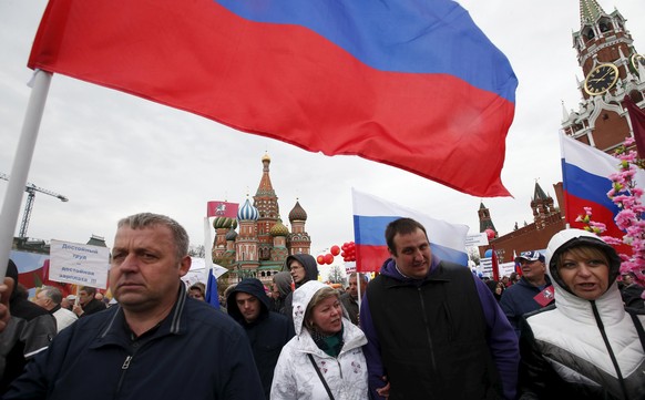 People walk with flags at Red Square during a May Day rally in Moscow May 1, 2015. International Workers&#039; Day, also known as Labour Day or May Day, commemorates the struggle of workers in industr ...