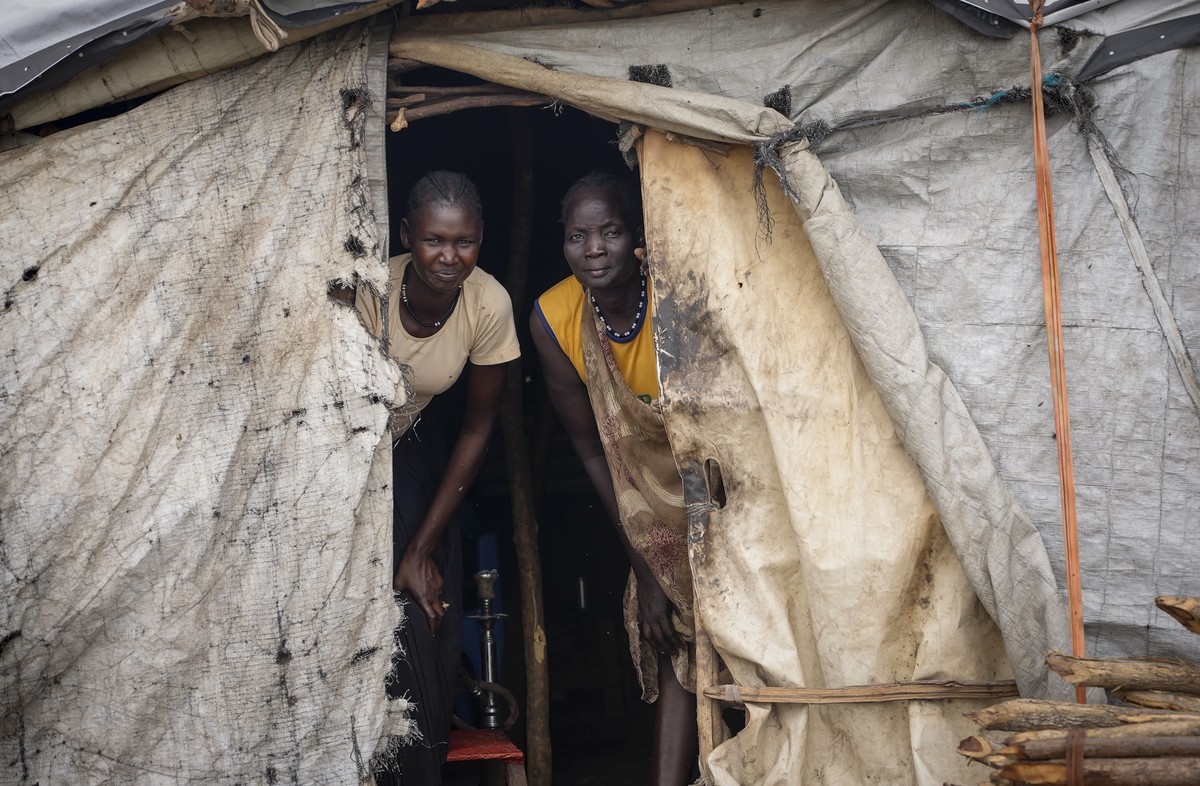 Two women peer out from their house in Kowach village in Canal Pigi county, Jonglei State, South Sudan Friday, May 5, 2023. In 18 months the country is due to hold presidential elections, the culminat ...